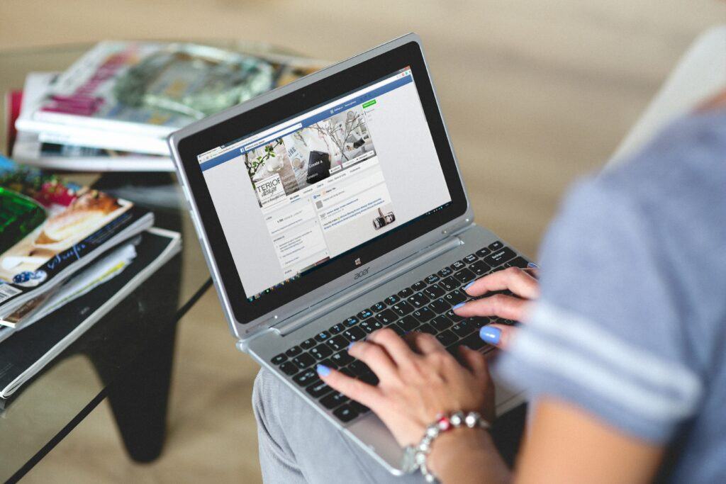 Woman typing on laptop in a Facebook Group.